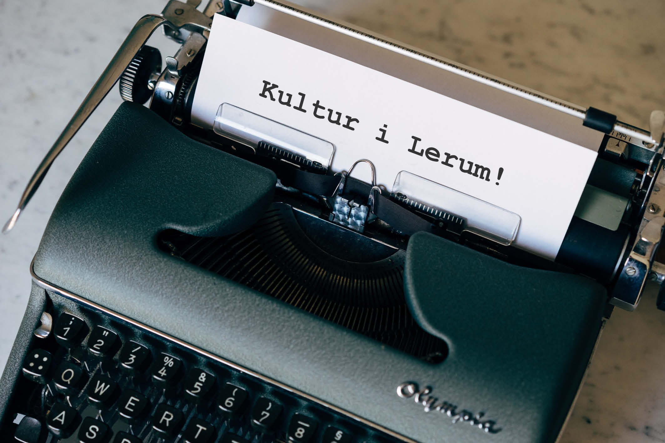 En äldre skrivmaskin med papper i där det står skrivet Kultur i Lerum